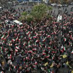 A group of demonstrators in Tehran wave Iranian flags in support of the government on Feb. 28, 2026.