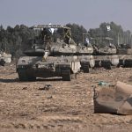 Armored Israeli military vehicles maneuver near Israel’s border with Gaza.