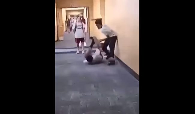 A capture from a brief video of a fight at Indian Trails Middle School, posted by the father of the boy being assailed in the video. The mother of the child faces a felony charge for her role in an alleged retaliation to the beating in the hallway.