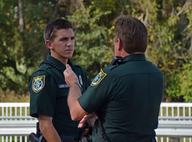 Palm Coast Precinct Cmdr. Mark Carman, right, speaks with deputy James Gore at the scene of a 2013 wreck involving Gore and a Palm Coast driver. Gore was found to have been careless in a case that led to the false arrest of a 19-year-old Bunnell man earlier this year. (© FlaglerLive)