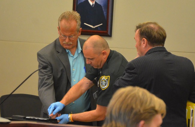 Jim Davis, left, being fingerprinted after his sentencing to a year's probation in circuit court Thursday. His attorney, Doug Williams, is to the right. (© FlaglerLive)