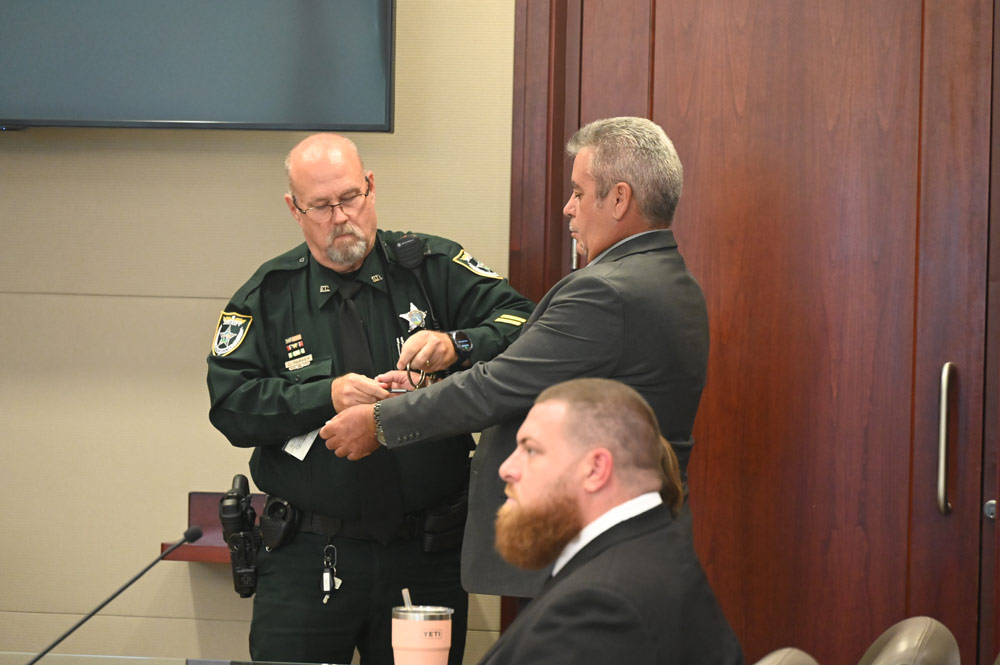 Flagler County Sheriff's Bailiff Carl Parker handcuffs Joao Fernandes after the verdict. (© FlaglerLive)