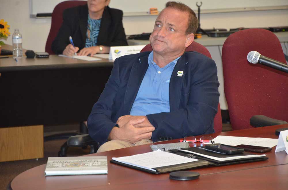 Joe Mullins at a Flagler County Commission workshop in 2019, holding his wrist two days after he was in a crash on State Road A1A. He was not at fault, according to a Florida Highway Patrol report. (© FlaglerLive)