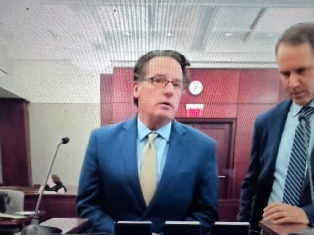 John Cacone, center, with his attorney John Hager, appearing before Circuit Judge Dawn Nichols on Tuesday in Bunnell. (© FlaglerLive via zoom)