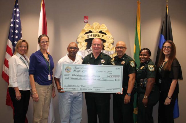 Flagler Sheriff's employees have been donating money all year to the charity Larry Jones established in 2008, for a total of $9,000 to be donated for Friday's shopping spree in the form of gift cards to 125 children. From left, Carol Skelton, Kathy Vazquez, Larry Jones, Sheriff Staly, Lou Miceli, Althea Civil, and Mary Dinardi.