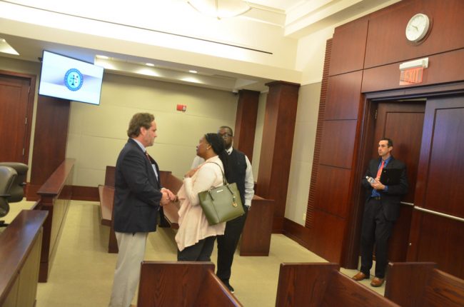 Attorney Josh Davis speaking with Kimberly Lee after the sentencing. Assistant State Attorney Jason Lewis is by the door. Lee's husband is just behind her. (© FlaglerLive)