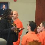 Assistant Public Defender Courtney Davison speaks with Joshua King, seated first from left, in court this morning. (© FlaglerLive)