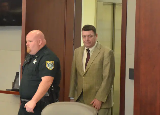Michael Bowling arriving for trial Monday behind deputy Brian Sheridan. (© FlaglerLive)