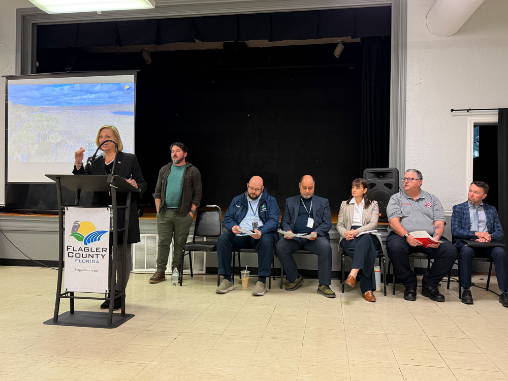 County Commissioner Kim Carney at Tuesday's town hall at the Wickline Center in Flagler Beach, with county administration staffers. (© FlaglerLive)