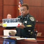 Flagler County Sheriff's deputy Avis Burroughs, one of the bailiffs at the courthouse, shows the jury the murder weapon, a chef's knife, Jermaine Williams Sr. used to kill his wife. (© FlaglerLive)