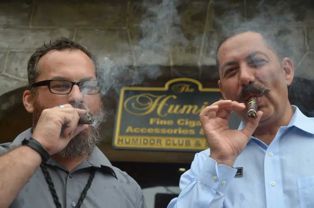 Doing what he loved with one of his closest friends: Ky Ekincy, right, with Mark Woods, outside the Humidor at European Village in 2015. (© FlaglerLive)