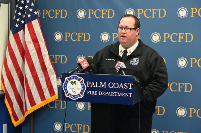 Palm Coast Fire Chief Kyle Berryhill, who was briefly overcome by emotion, addressing reporters at a late-morning press conference at Fire Station 21 today. (© FlaglerLive)