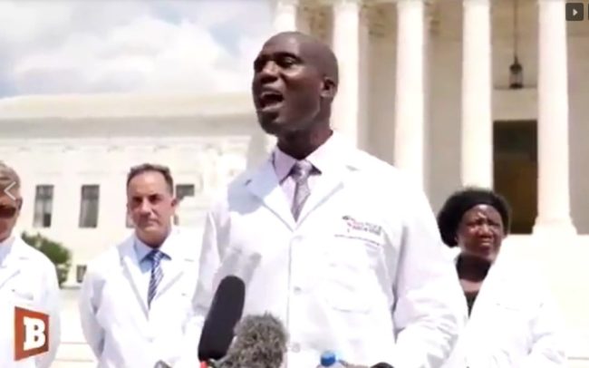 Dr. Joseph Ladapo, in an “America’s Frontline Doctors” lab coat, speaks at a July 2020 event that included Stella Immanuel, a doctor who said “demonic seed” causes ovarian cysts and endometriosis. (Screenshot from YouTube)