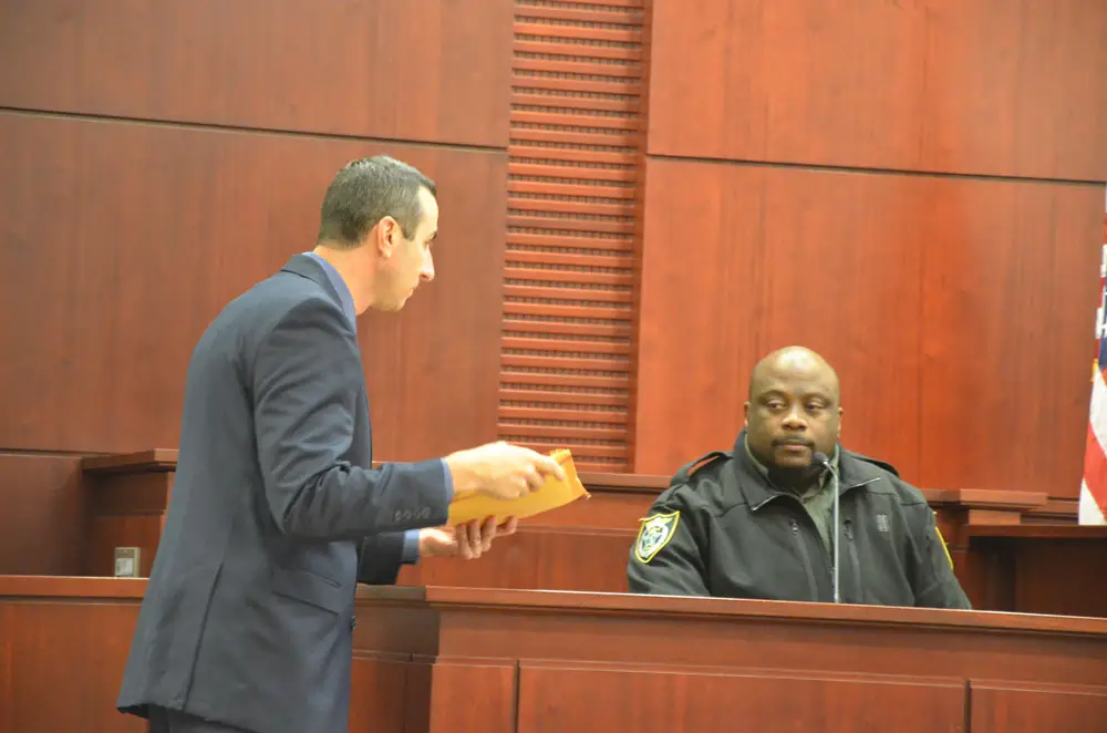 Assistant State Prosecutor Jason Lewis, left, shows FPC School Resource Deputy Jason Williams the computer the 16-year-old girl (now 17) used to write her side of the chat at the heart of the case, with another student, last December. Circuit Judge Chris France heard the case in a non-jury trial last week. A decision is expected in the next few days. (© FlaglerLive) 