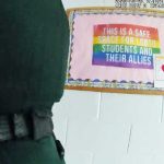 The sign above, ina classroom that used to be the gathering place for Matanzas High School's Gay-Straight Alliance, was glimpsed for less than two seconds in a sheriff's body cam video of the arrest of a Matanzas student ion Tuesday. The sign nevertheless caught the attention of School Board member Christy Chong, who demanded that it be taken down. (© FlaglerLive via sheriff's Axon video)