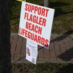 The lifeguard program in Flagler Beach has often seemed to be on the brink, as it seemed to be three years ago, when signs like the one above appeared around town. The county and the city are hoping to work toward a more stable funding source, in part using tourism tax revenue. (© FlaglerLive)