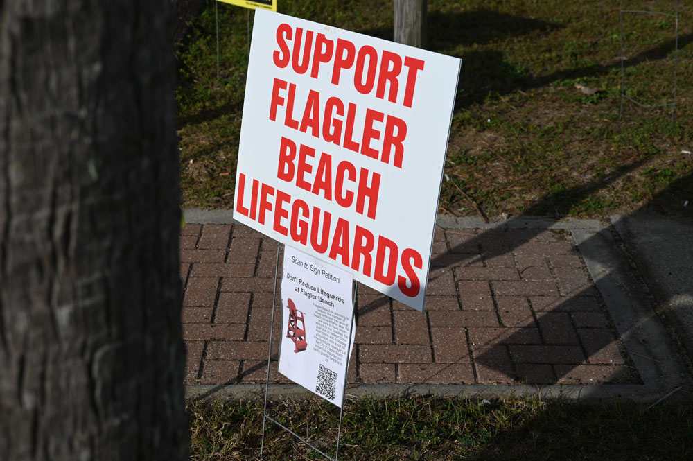 The lifeguard program in Flagler Beach has often seemed to be on the brink, as it seemed to be three years ago, when signs like the one above appeared around town. The county and the city are hoping to work toward a more stable funding source, in part using tourism tax revenue. (© FlaglerLive)