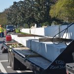 Workers with L&S Lighting getting set to plant more concrete light poles on the east side of Belle Terre Parkway near Buddy Taylor Middle School on Monday, part of the project to light up the parkway. (© FlaglerLive)