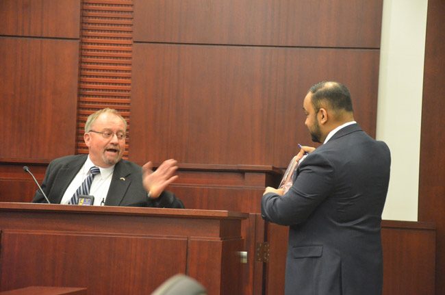 Former FDLE Agent Philip Lindley on the stand, addressing the search warrant he had drafted ahead of a search of then-Supervisor of Elections Kimberle Weeks's office, under questioning from Weeks attorney Kendell Ali. (© FlaglerLive)