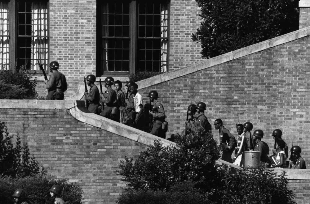 Soldiers from the 101st Airborne Division escort the Little Rock Nine students into the all-white Central High School in Little Rock, Ark.