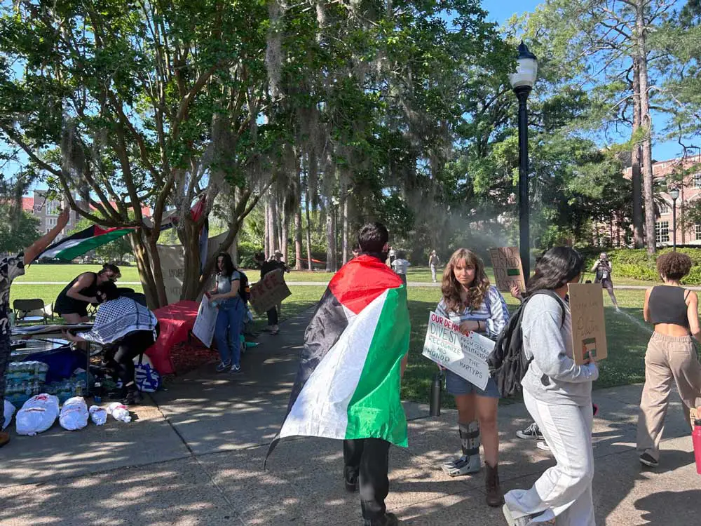 Pro-Palestine protesters at Florida State University move away from a sprinkler during a protest on the Tallahassee campus on April 25, 2024. (Photo by Jackie Llanos)
