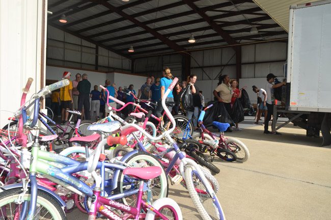 Some 150 volunteers gathered at the Flagler County airport Wednesday to load three box trucks and five trailers with toys for 1,300 children, the work of Flagler Beach Rotary's Project Share. (© FlaglerLive)