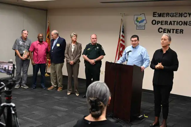 Local officials presented a united front at a press conference late this afternoon. From right, next to a sign language interpreter, Emergency Management Chief Jonathan Lord, Sheriff Rick Staly, Superintendent Cathy Mittlestadt, Palm Coast Mayor David Alfin, Bunnell City Manager Alvin jackson and Flagler Beach City Manager William Whitson. (© FlaglerLive)