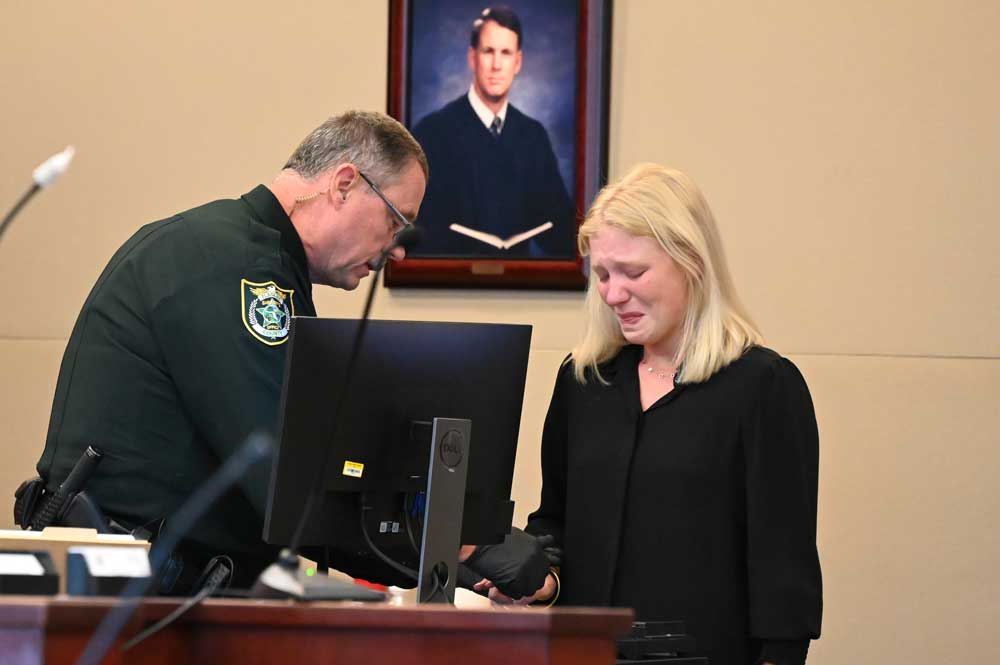 Brooke Lorenzen, 20, getting fingerprinted after her sentencing hearing late this morning before Circuit Judge Terence Perkins at the Flagler County Courthouse. (© FlaglerLive)