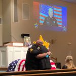 Sheriff Rick Staly hugging Brian Luciano, one of Paul Luciano's children, at the detention deputy's funeral service on Sept. 3. (FCSO)