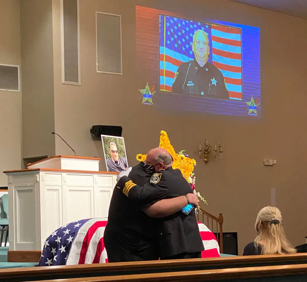 Sheriff Rick Staly hugging Brian Luciano, one of Paul Luciano's children, at the detention deputy's funeral service on Sept. 3. (FCSO)