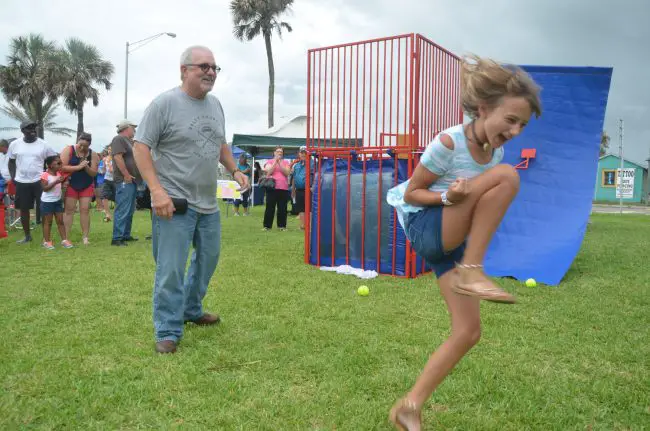 Makena Lukasik, daughter of Amy Lukasik, celebrates Friday after dunking Flagler Beach Police Chief Matt Doughney. Doughney, Bunnell Polioce Chief Tom Foster and Flagler County Sheriff Rick Staly all volunteered to be dunked, repeatedly, as part of a Police Athletic League fund-raiser for the Special Olympics, which raised $324. Click on the image for larger view. (© FlaglerLive)