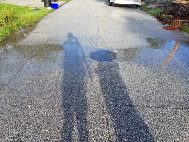 A manhole cover drowning on Round Tree Drive in Palm Coast today. (© David Roure for FlaglerLive)