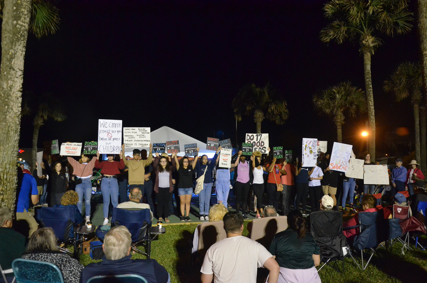 The students' march ended at Veterans Park during First Friday, where the names of the 17 victims of the Parkland massacre were read out loud as students held signs of the the names of those killed. Click on the image for larger view. (© FlaglerLive)
