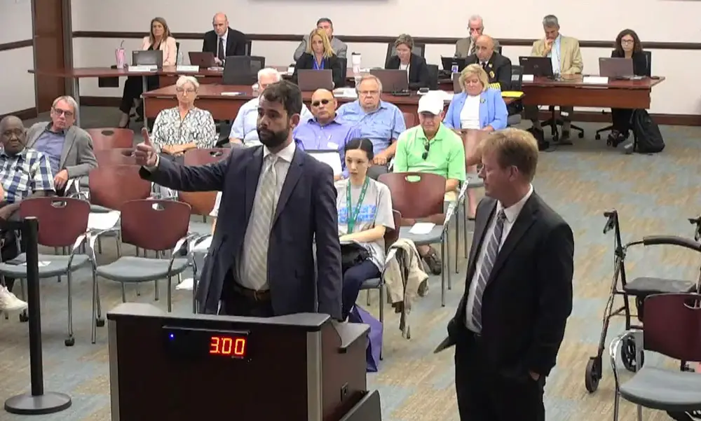 Chris Marlow, left, who manages the Green Lion Cafe, with his attorney, John Ferguson. Marlow was not showing the thumbs up to the Palm Coast City Council last night, but enumerating utility costs and how they could be incorporated in the rent. (© FlaglerLive via Palm Coast YouTube)