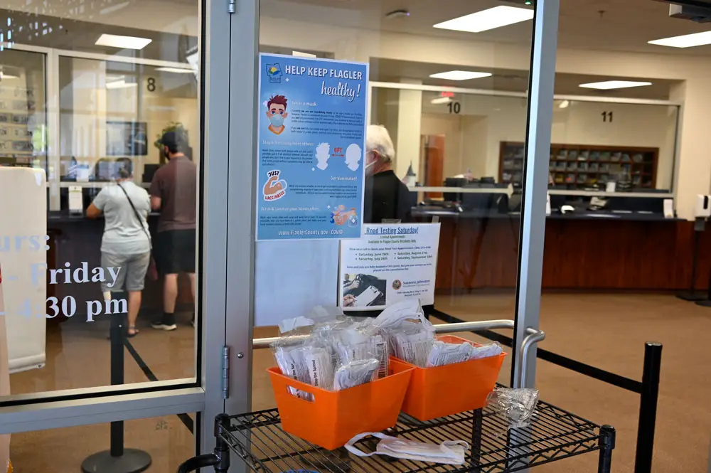 Mask stations like this one, along with mask and vaccine messaging, have sprouted in local government buildings in a reflection of a more concerted recent effort to encourage residents to mask and take precautions against the spread of the delta variant of the coronavirus. (© FlaglerLive)