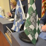School Board member Andy Dance displayed the flags of the two high schools' Class of 2020 at a board meeting a few weeks ago. The shape of the Class of 2021 is in flux. (© FlaglerLive)