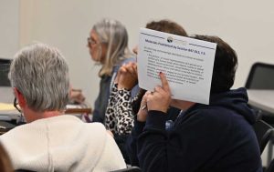 Materials prohibited: Shannon Rambow, who is seeking to ban "The Nowhere Girls," hid her face from the camera during today's meeting. Terri McDonald, another of the three individuals who have filed all 44 challenges to books this year, sat to Rambow's left. (© FlaglerLive)