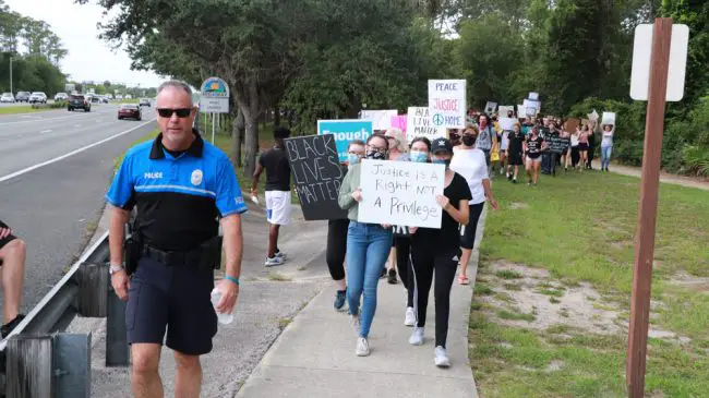 Flagler Beach Police Chief walked at the head of the march in both directions. (© Weldon Ryan for FlaglerLive)