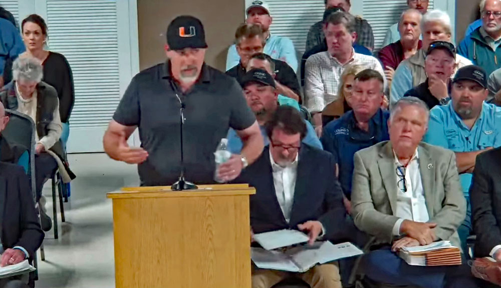 Matt Hathaway, a member of Preserve Flagler Beach and Bulow Creek, asking the Flagler Beach City Commission for some assurances about a potential land sale to preserve 153 acres around the headwaters of Bulow Creek. Ken Belshe, the developer of Sumertown, is to the right in the front row, next to attoirney Michael Chiumento. (© FlaglerLive)