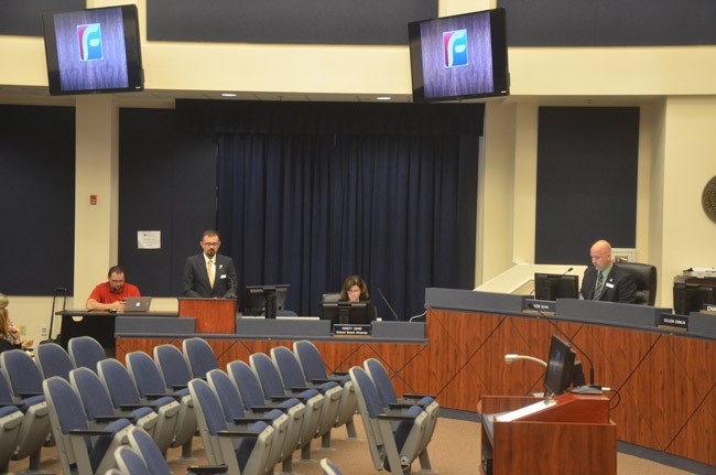 'The meetings aren't usually this somber,' Colleen Conklin who chairs the school board, said at the end of Tuesday's meeting, after Kevin McCarthy, director of the district's adult and community education division (standing, toward the left)  presented a scaled-down Adults With Disabilities program for the board's approval. Superintendent Jacob Oliva is to the right. (© FlaglerLive)