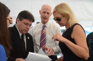 Gov. Scott with Economic Development Director Helga van Eckert and County Commission Chairman Nate McLaughlin, goingt over the morning's script. Click on the image for larger view. (© FlaglerLive)
