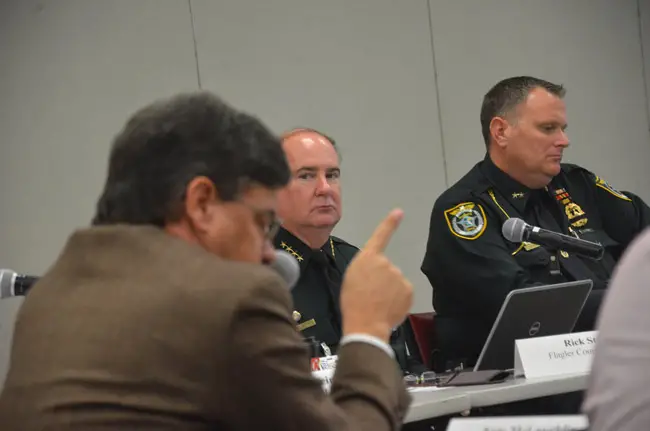 Nate McLaughlin, in the foreground, chairing the Public Safety Coordinating Council. He is also the chairman of the Flagler County Commission. He says the civil-citation program to decriminalize pot possession in small amounts will go forward to a vote at the County Commission. But Sheriff Staly, center, is not a fan of the program, and without his backing its implementation may be moot. (© FlaglerLive)