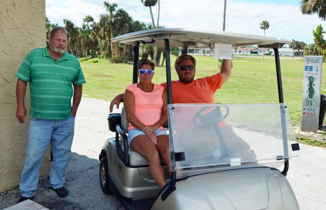 Duane McDaniel. left, and his son Craig, with volunteer Monique Recker. Click on the image for larger view. (© FlaglerLive)