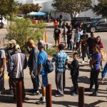 Groups of migrants wait for food donations in San Antonio on Sept. 19, 2022. (Jordan Vonderhaar/Getty Images)