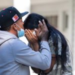 An undocumented immigrant from Venezuela kisses the forehead of another immigrant on the island of Martha’s Vineyard in Massachusetts. (Dominic Chavez for The Washington Post via Getty Images)