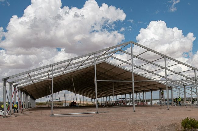 A construction crew assembles temporary soft sided facilities in El Paso, Texas, April 23, 2019. The facilities will be used for processing, care and transfer of record numbers of migrants including families and unaccompanied children 