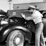 A U.S. Border Patrol officer shows how he found an undocumented Mexican immigrant under the hood of a car along the U.S.-Mexican border in March 1954.