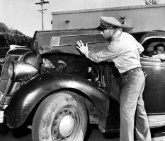 A U.S. Border Patrol officer shows how he found an undocumented Mexican immigrant under the hood of a car along the U.S.-Mexican border in March 1954.