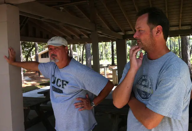 Drew Miller, left, and Darren Miller, spoke of their father Raymond as a salvage operation for Raymond's crashed plane continued a distance away in Pellicer Creek marshes. (© FlaglerLive)