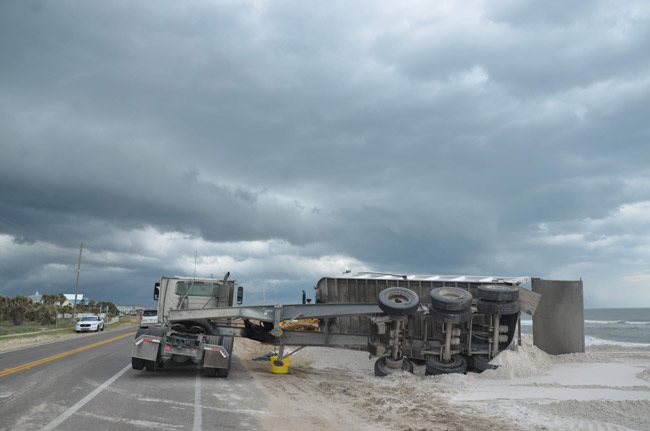 A bit of a mishap on the north A1A sea wall project last week: as the storm was gathering on Good Friday, wind blew over a dump truck, damaging its chassis. No one was hurt. Traffic was not impeded. The project carries on. (© FlaglerLive)